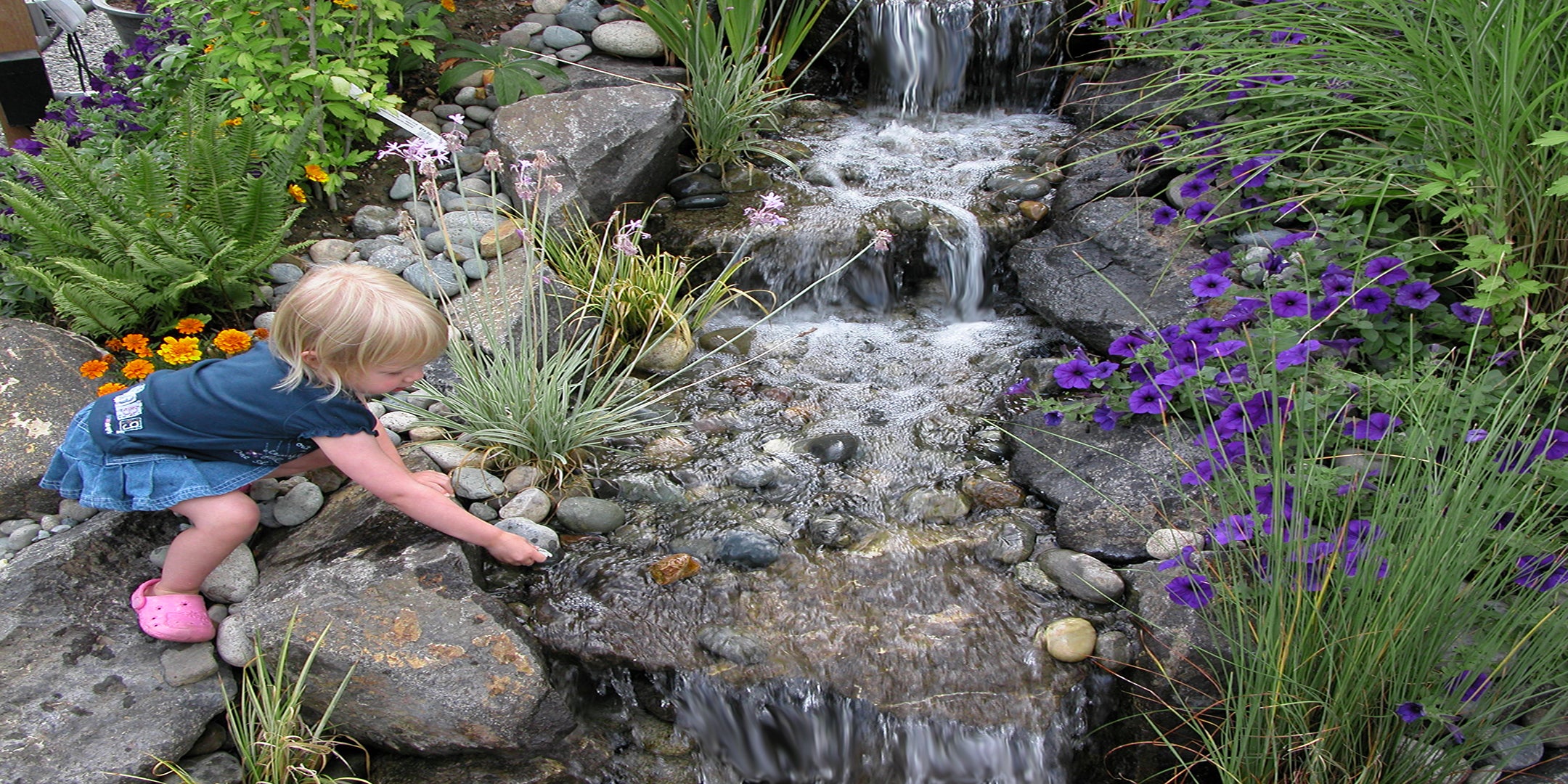 Three step waterfalls with a child placing stones in the water